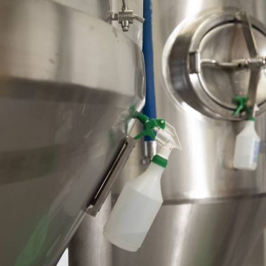Sanitizer spray bottles hanging on fermenters